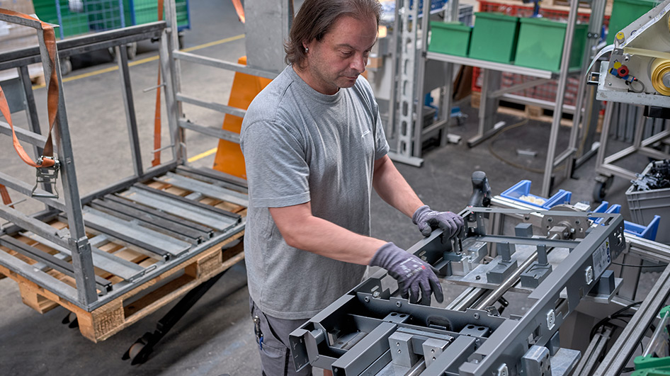 A member of staff assembles the frame structure for a Monolith sanitary module.