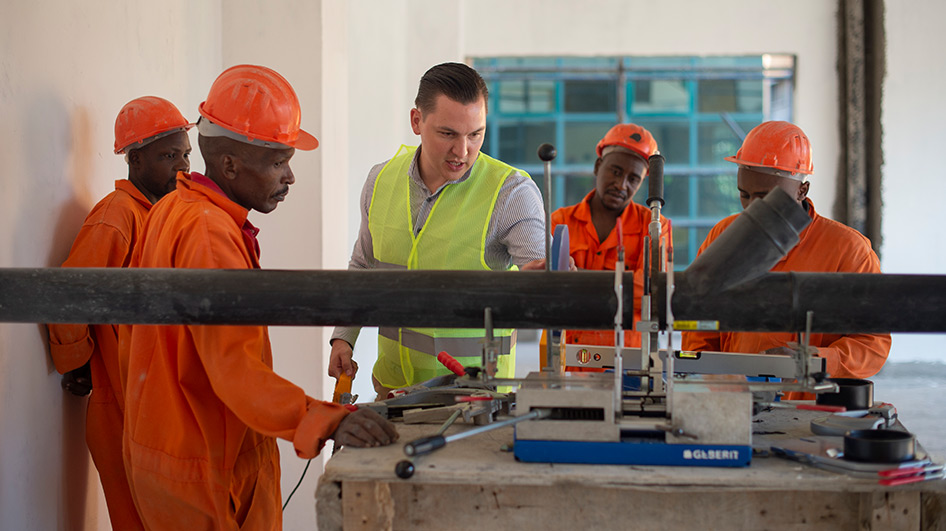 The trained plumber (centre) trains Kenyan specialists on how to install Geberit components.