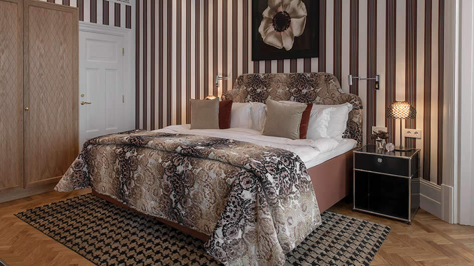 The room walls feature intricate, floral art photography plus striped wallpaper.