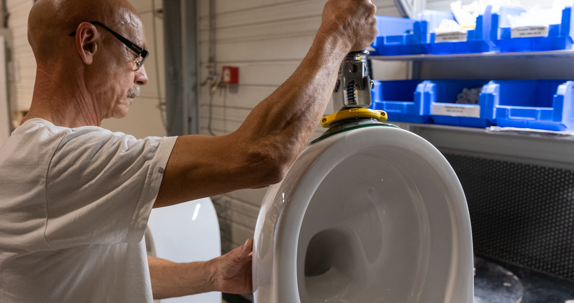 An employee lifts a ceramic WC with the help of the lifting aids