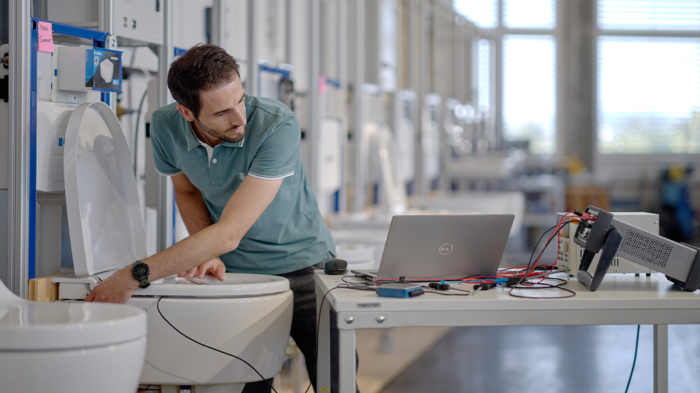 Danilo Corciulo checks the temperature flush mode on a shower toilet  