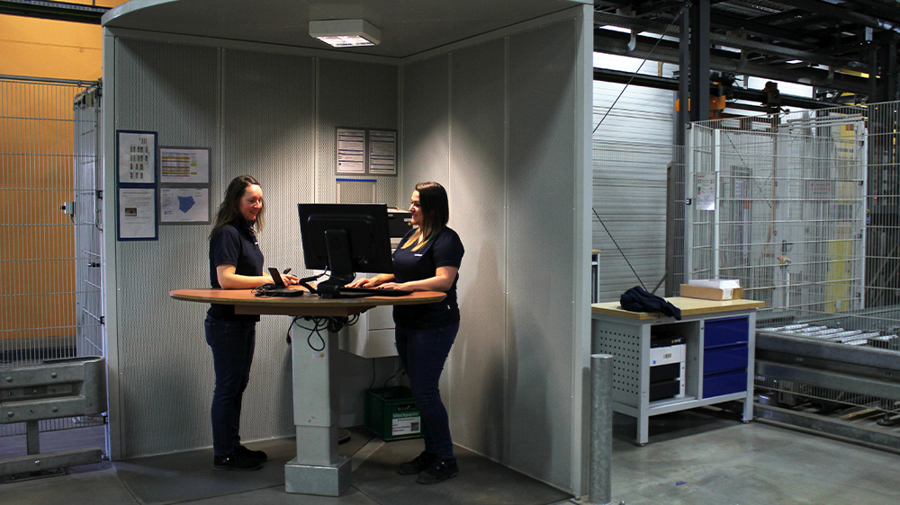 Marion Glückler in a meeting with a work colleague in meeting room in the logistic center 