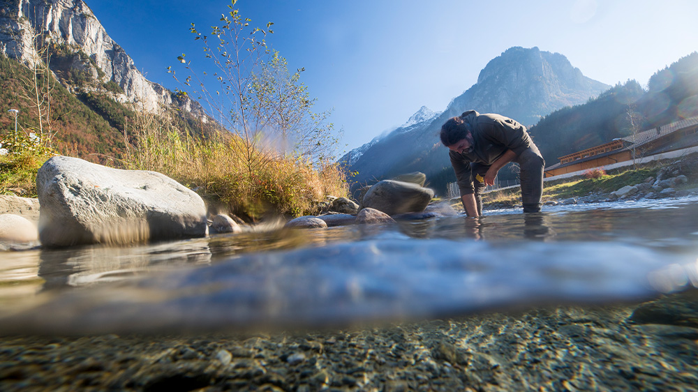 A man stands in a mountain stream  