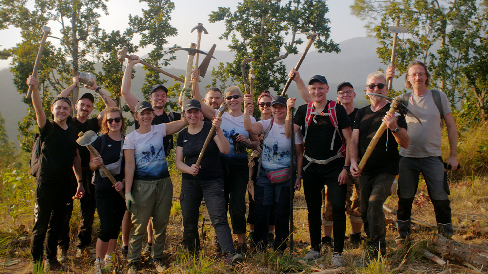 A group photo of the Geberit volunteers in Nepal holding digging tools 