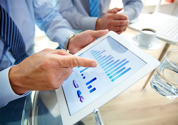 Two individuals reviewing business charts on a tablet