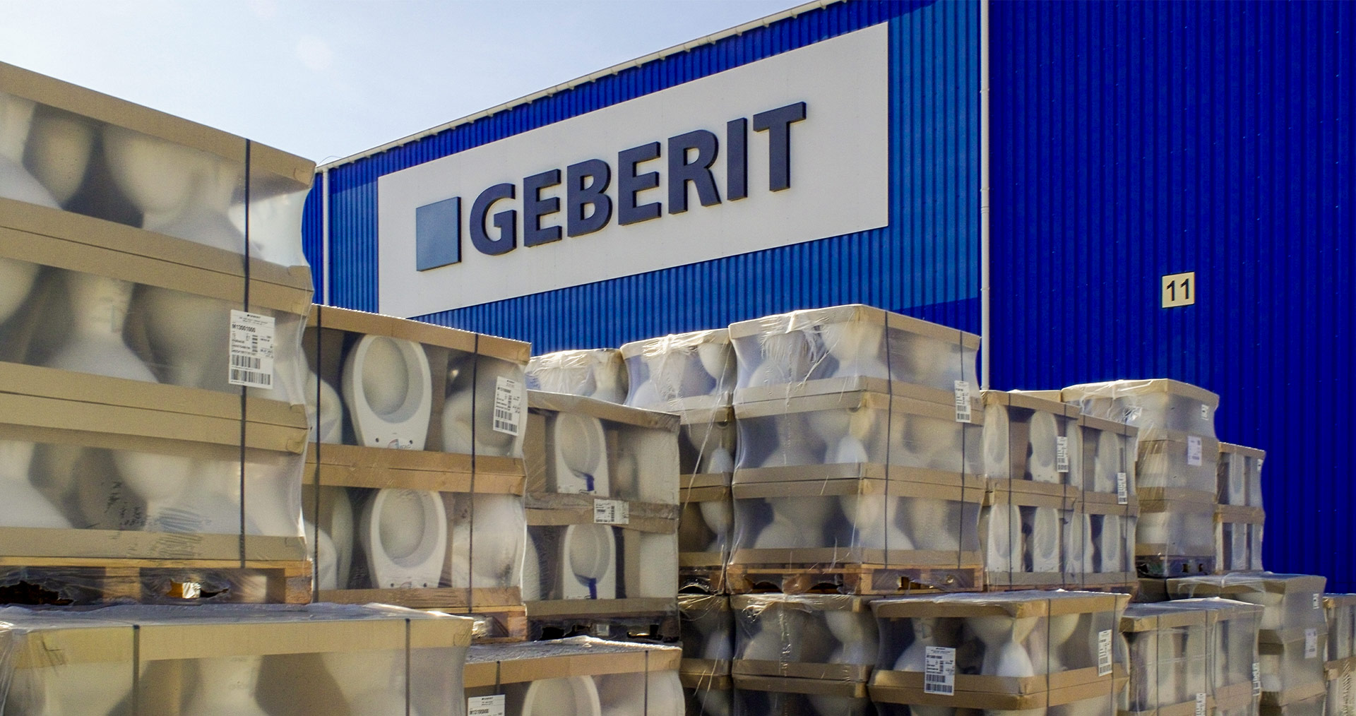 Storage area with stacked Geberit products in front of the company building