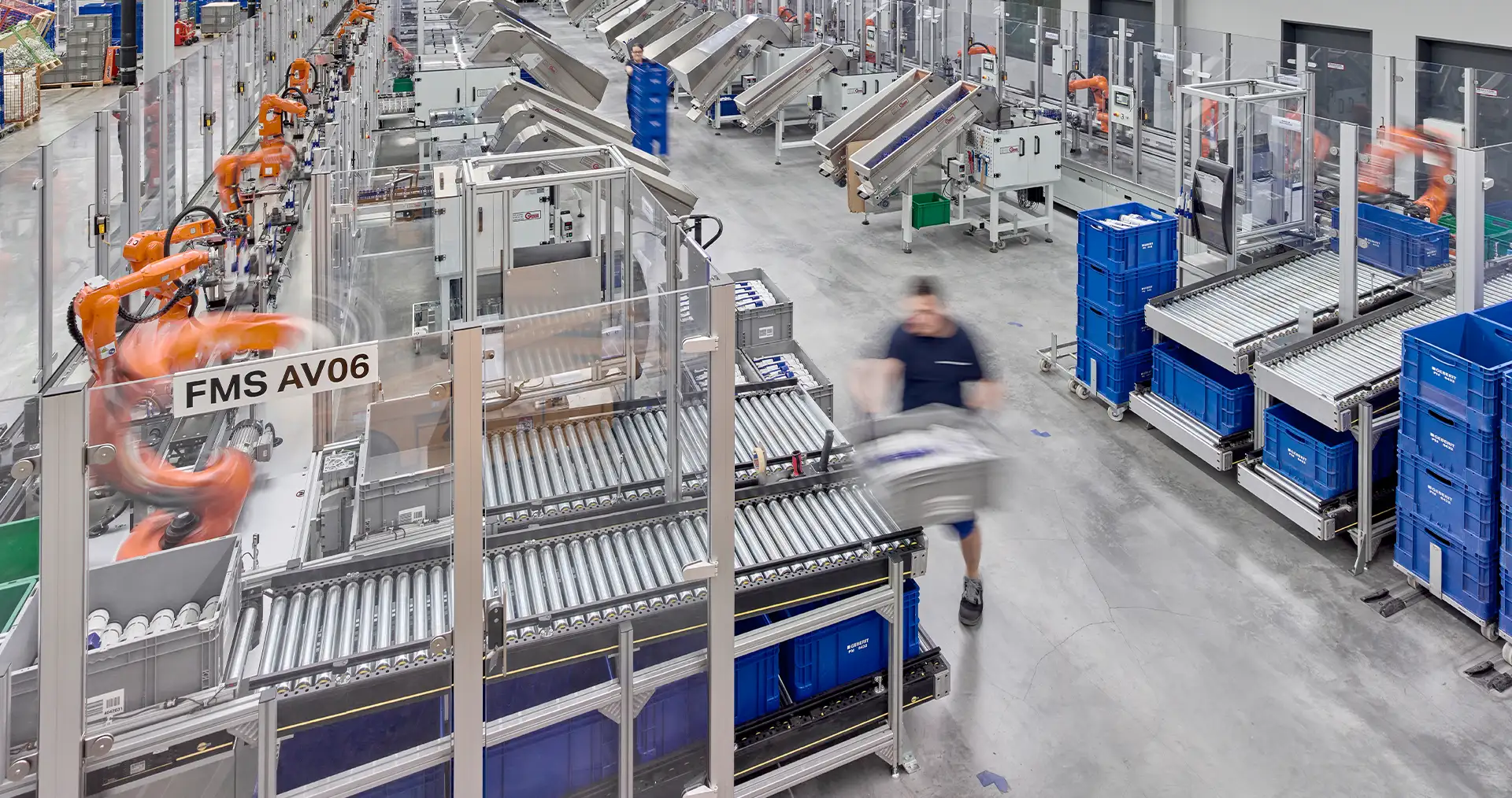 Modern factory floor with robots and workers conducting production and logistics operations