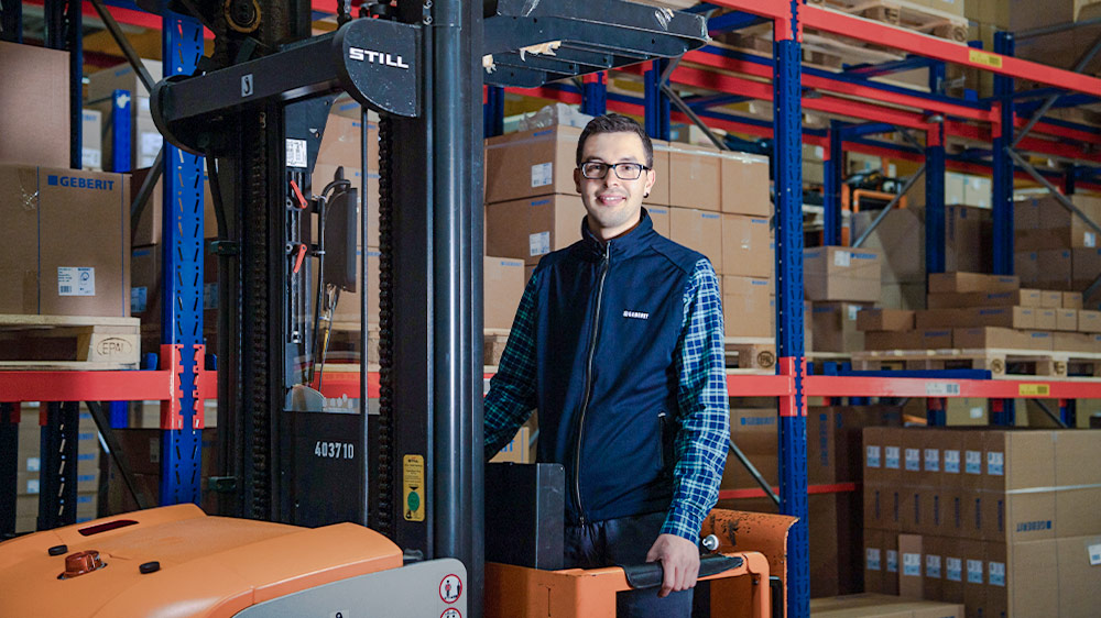 Stefan Matheis next to a forklift in the Geberit warehouse