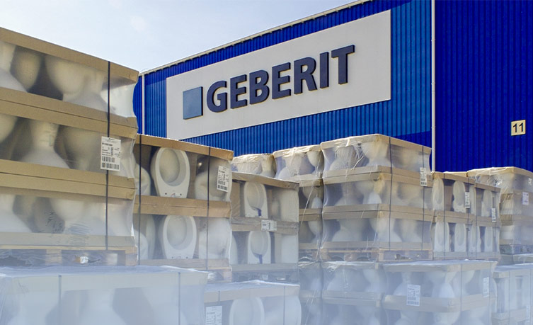 Storage area with stacked Geberit products in front of the company building