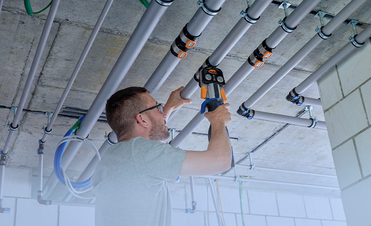 Craftsmen installing the Geberit FlowFit pipe system, simplifies the installation process