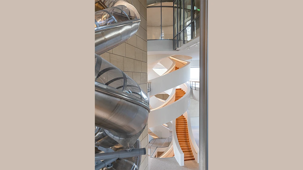 Interior architecture of the Luma Cultural Centre in Arles featuring a striking spiral staircase and slide