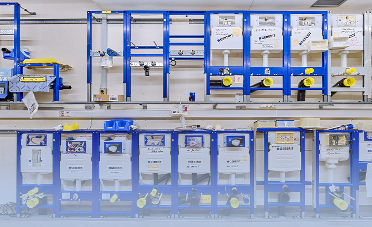 Storage rack with various models and spare parts for Geberit cisterns, demonstrating the long-term availability of spare parts