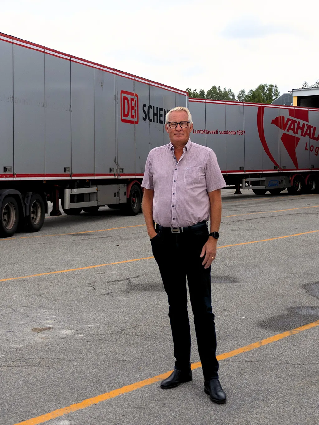 A man standing in front of a super-size truc with multiple trailers in Sweden.