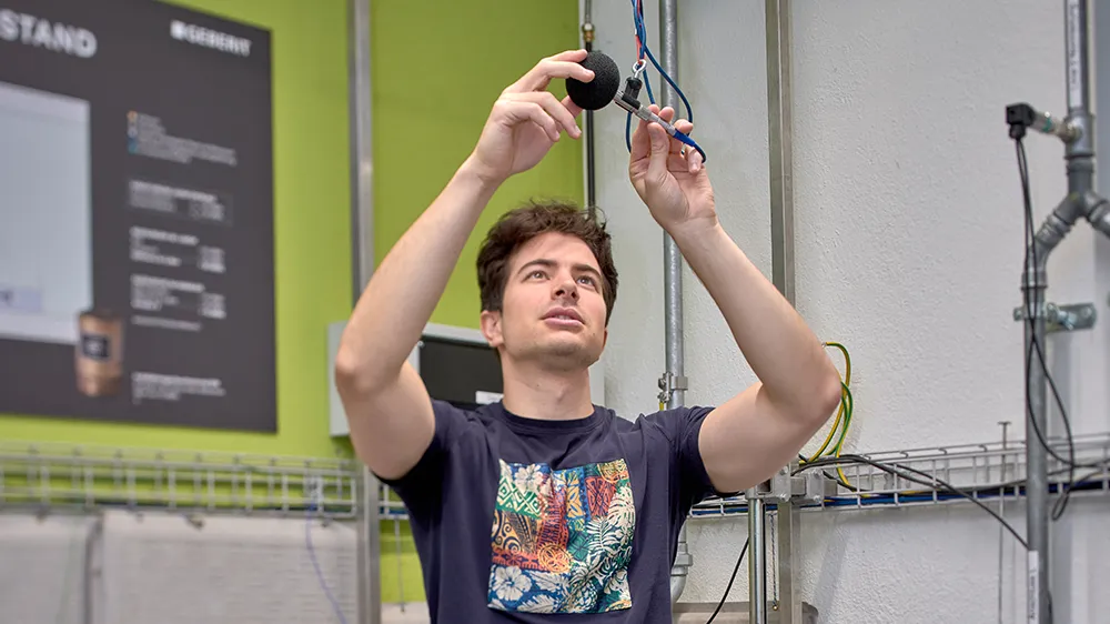 Pietro Allegri sets up the microphone for measuring airborne sound in the installation room.&nbsp; (Photo)