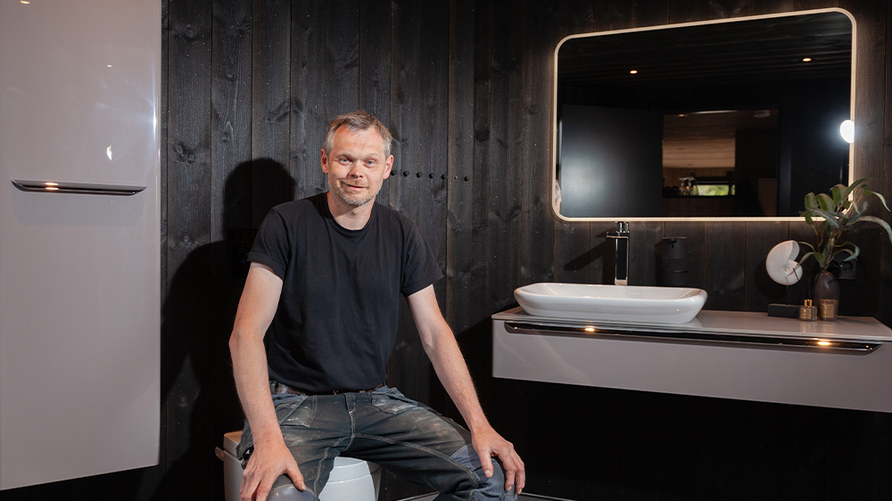 Eigentümer und Bauherr Knut Eivind Birkeland sitzt im Badezimmer 