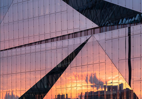 Sonnenuntergang spiegelt sich in der Glasfassade eines Gebäudes