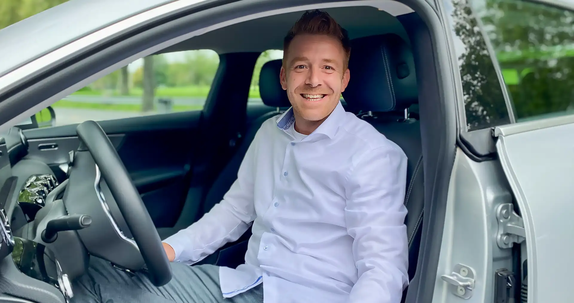 Benjamin Keller, Verkaufsberater bei Geberit, lächelt im Auto auf dem Weg zu Kunden