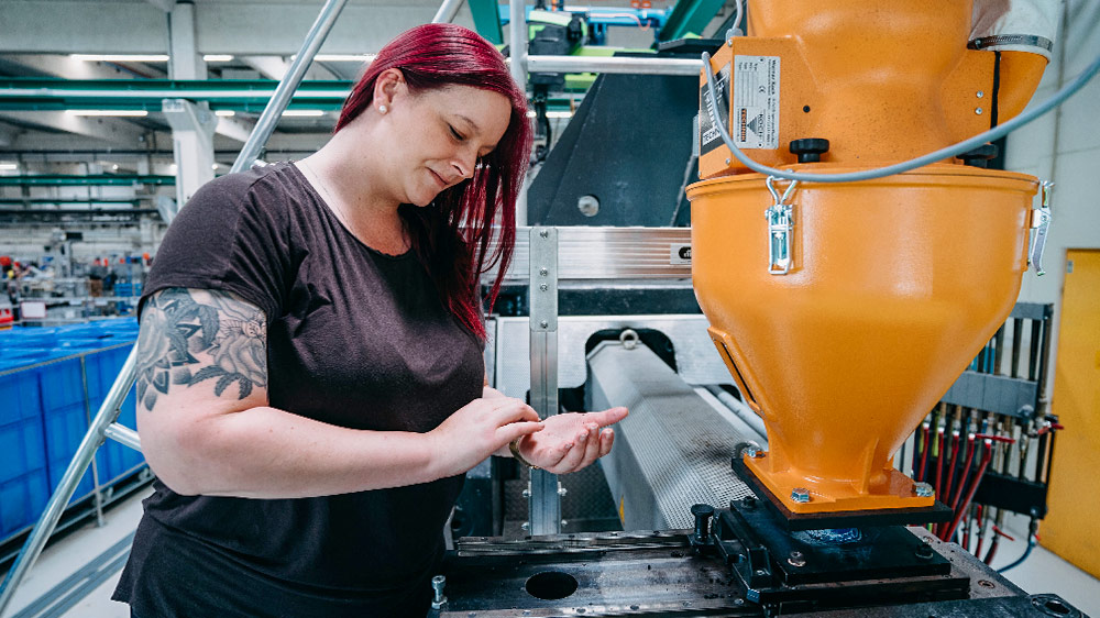 Sarah Berner, bei der Arbeit in der Geberit Fabrik, überprüft eine Maschine