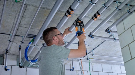 Handwerker bei der Installation von Geberit FlowFit Rohrsystem, vereinfacht den Installationsprozess