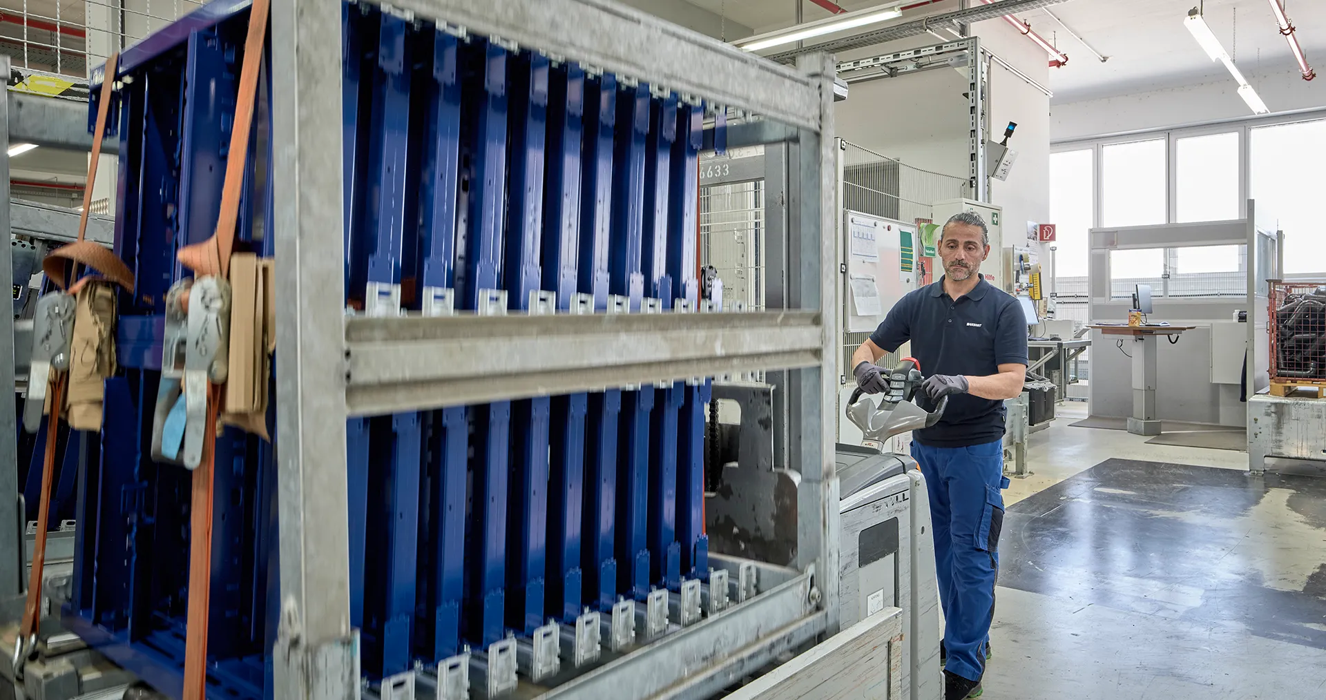 Fabrikarbeiter in Geberit-Arbeitskleidung bei der Arbeit in einer Produktionshalle. (Foto)