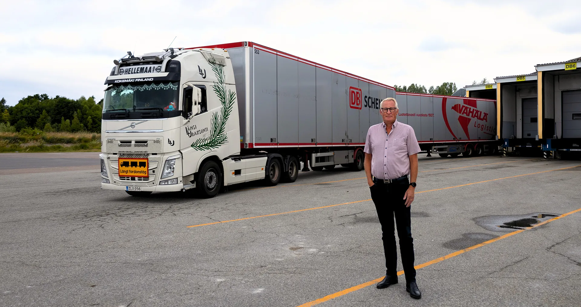 Ein Mann steht vor einem riesigen Lkw mit mehreren Anhängern in Schweden. (Foto)