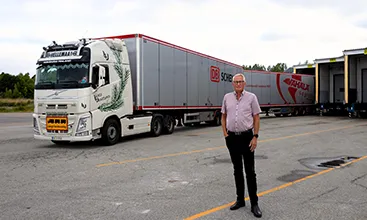 Ein Mann steht vor einem riesigen Lkw mit mehreren Anhängern in Schweden. (Foto)